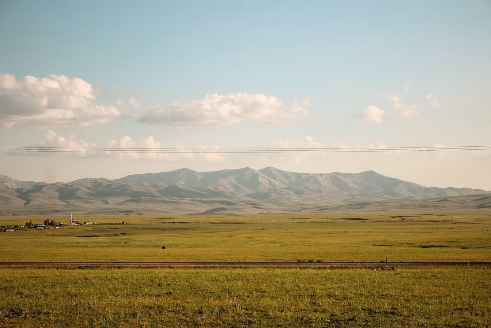 Rolling grassland stretching to distant hills.