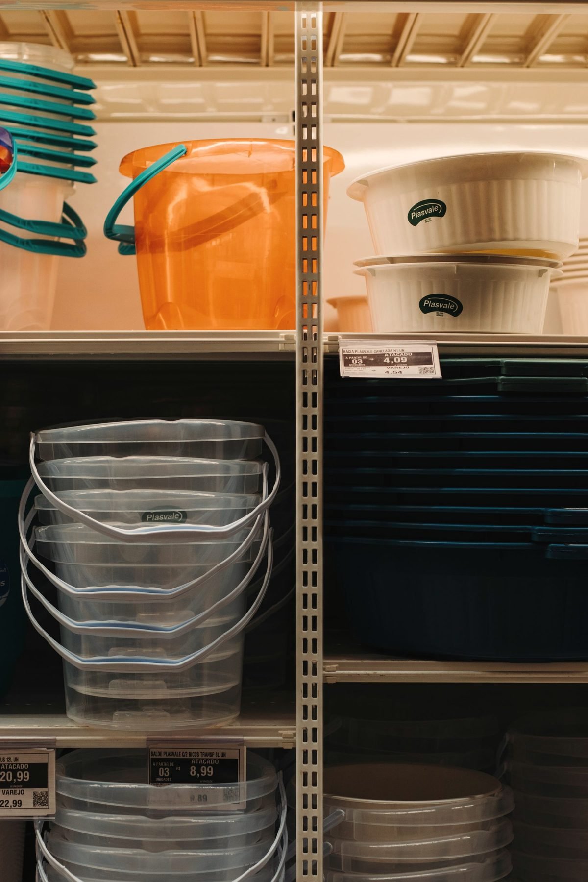 Buckets, jugs, and tubs lined along ranch supply shelves.